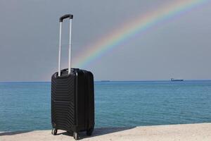 une valise est permanent sur une plage avec une le coucher du soleil dans le Contexte. voyage, vacances et vacances cons. été temps. photo