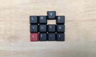 l'amour toi même mot sur noir clavier bouton sur bois arrière-plan, l'amour toi même concept photo
