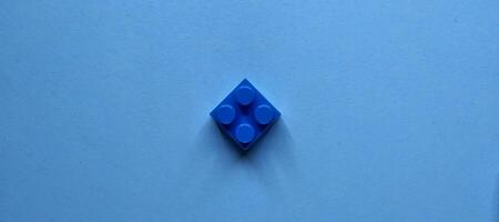 Plastique bâtiment blocs sur une bleu Contexte. minimal concept. photo