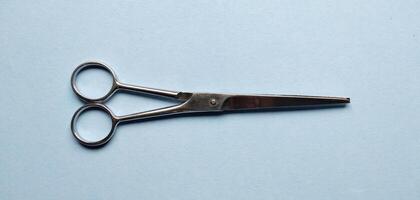 cheveux Coupe les ciseaux sur bleu Contexte. coiffeur outils. photo