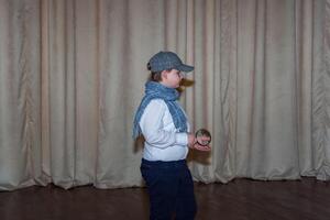 une mignonne adolescent garçon dans une casquette et une plaid foulard. le image de une détective. grossissant verre dans main. photo