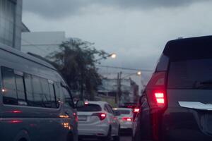 arrière côté vue de voiture avec tour sur frein lumière. environnement de voiture dans le soir temps. se ruer heure dans le ville. circulation confiture sur le route dans Thaïlande. photo