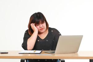 graisse asiatique femme est assis à travail en utilisant portable ordinateur pour une longue temps. elle se sentait fatigué et stressé. concept de santé se soucier pour obèse personnes. santé problèmes. blanc Contexte. photo