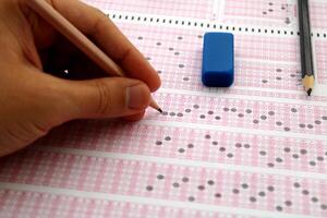 examen, une main prise une tester avec une crayon plus de un optique lecteur. futur anxiété. incertitude. photo