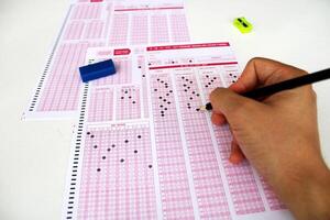 examen, une main prise une tester avec une crayon plus de un optique lecteur. futur anxiété. incertitude. photo