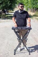 dj avec écouteurs et mixer dans le parc, le dj à travail photo