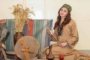 arménien Jeune femme dans traditionnel vêtements travail dans Accueil photo