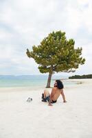 Jeune musclé homme exercice sur le plage, Jeune musclé homme Faire musculation des exercices sur le plage, athlétique Jeune homme sur le plage photo