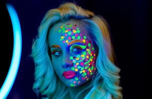 portrait de une femme avec peint affronter, femme avec uv maquillage dans studio, portrait de une femme dans carnaval masque, le femme est décoré dans une ultra-violet poudre photo