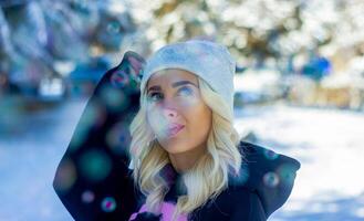 portrait de une femme dans une parc, portrait de une femme dans hiver parc, portrait de une blond femme, femme dans chapeau photo