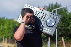 dj avec écouteurs et mixer dans le parc, le dj à travail photo