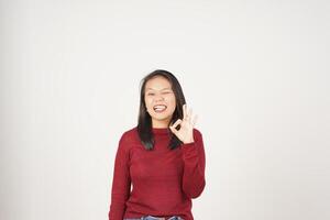 Jeune asiatique femme dans rouge T-shirt souriant et montrant d'accord signe isolé sur blanc Contexte photo