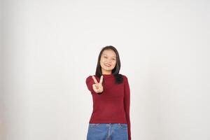 Jeune asiatique femme dans rouge T-shirt souriant et montrant paix ou la victoire signe montrant isolé sur blanc Contexte photo