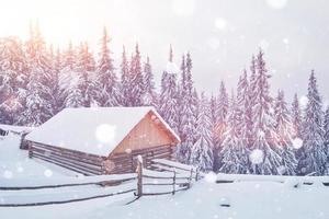 bâtiment clôturé en bois se dresse sur la colline des montagnes d'hiver photo