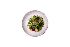 délicieux Frais salade avec roquette, épinard, concombre et Cerise tomates dans une céramique assiette photo