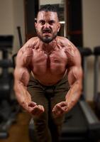 bodybuilder formation le sien muscles dans salle de sport, bodybuilder formation avec haltère photo