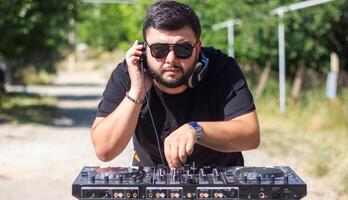 dj avec écouteurs et mixer dans le parc, le dj à travail photo