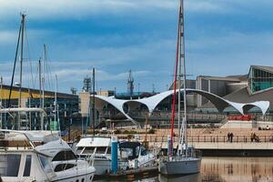 Marina avec yachts contre une toile de fond de moderne architecture et nuageux ciel. photo