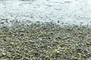 l'eau gouttes sur le plage, proche en haut de une le sable sur le plage photo