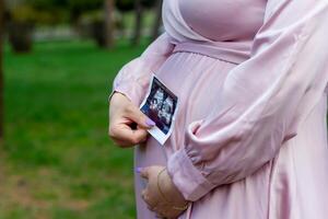 le Enceinte femme dans le parc, magnifique femme dans le parc, Enceinte femme dans printemps photo