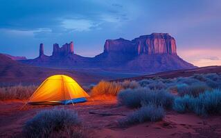ai généré tente brille en dessous de désert crépuscule contre majestueux Roche formations photo
