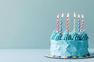 ai généré bleu gâteau sur une supporter avec allumé bougies sur une bleu Contexte photo
