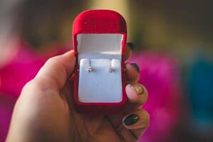 bijoux bague dans une rouge boîte dans le mains de une fille photo