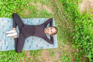 jolie fille Faire yoga des exercices, peu fille Faire yoga des exercices dans le jardin photo