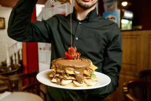 homme en portant une assiette avec une gâteau photo