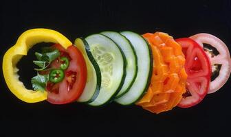 ai généré tranché des légumes sur une noir Contexte. végétarien aliments. photo