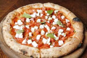 fermer de une pepperoni Pizza sur une en bois table photo