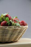 une panier de des fraises sur une en bois Couper planche sur blanc Contexte photo