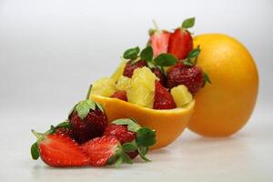 une fruit bol avec des fraises, des oranges, et tranche de étoile fruit photo