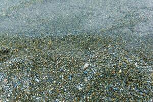 l'eau gouttes sur le plage, proche en haut de une le sable sur le plage photo