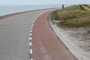 asphalte route avec cycle chemin le long de néerlandais Nord mer dune photo