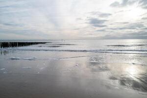 Nord mer côte, sombre le coucher du soleil derrière pluie des nuages photo