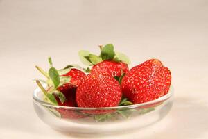 une bol de des fraises sur une blanc table Haut studio photo