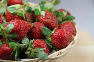 une panier de des fraises sur une en bois Couper planche sur blanc Contexte photo