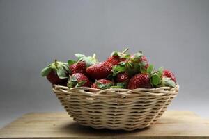 une panier de des fraises sur une en bois Couper planche sur blanc Contexte photo