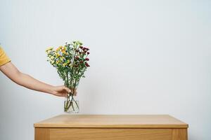 femme main organiser coloré fleurs bouquet dans le maçon pot sur table Contexte. content journée avec Frais fleur photo