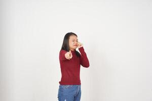 Jeune asiatique femme dans rouge T-shirt triste pleurs et montrer du doigt à caméra isolé sur blanc Contexte photo