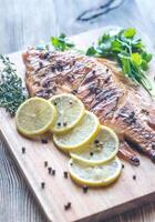 grillé tilapia avec herbes sur le en bois planche photo