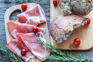 tranches de jambon sur la planche de bois photo