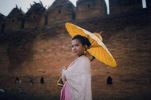 fille dans thaïlandais costume à tha phaé porte vieux ville dans chiang mai Thaïlande photo