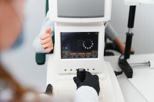 vision correction dans une garçon. fermer visage de patient garçon. super moderne équipement dans une moderne clinique pour œil examen. photo