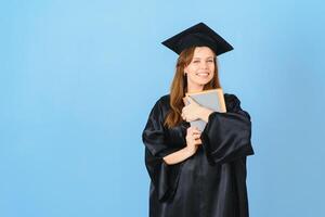 magnifique femme portant l'obtention du diplôme casquette et la cérémonie peignoir en portant diplôme à la recherche positif et content permanent et souriant avec une sur de soi sourire. photo