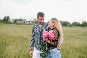 Jeune couple des promenades dans le parc pendant le printemps et câlins. profiter temps ensemble. le concept de jeunesse, l'amour et mode de vie photo