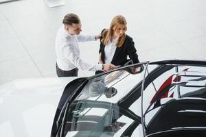 Jeune magnifique content couple achat une auto. mari achat voiture pour le sien épouse dans une salon. voiture achats concept photo