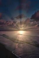 coucher de soleil, illuminé mer. sablonneux plage dans le premier plan. lumière vagues. baltique mer photo
