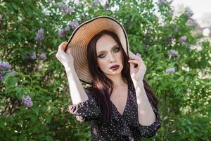 une à la mode fille avec foncé cheveux, une printemps portrait dans lilas tons dans été. brillant professionnel se maquiller. photo